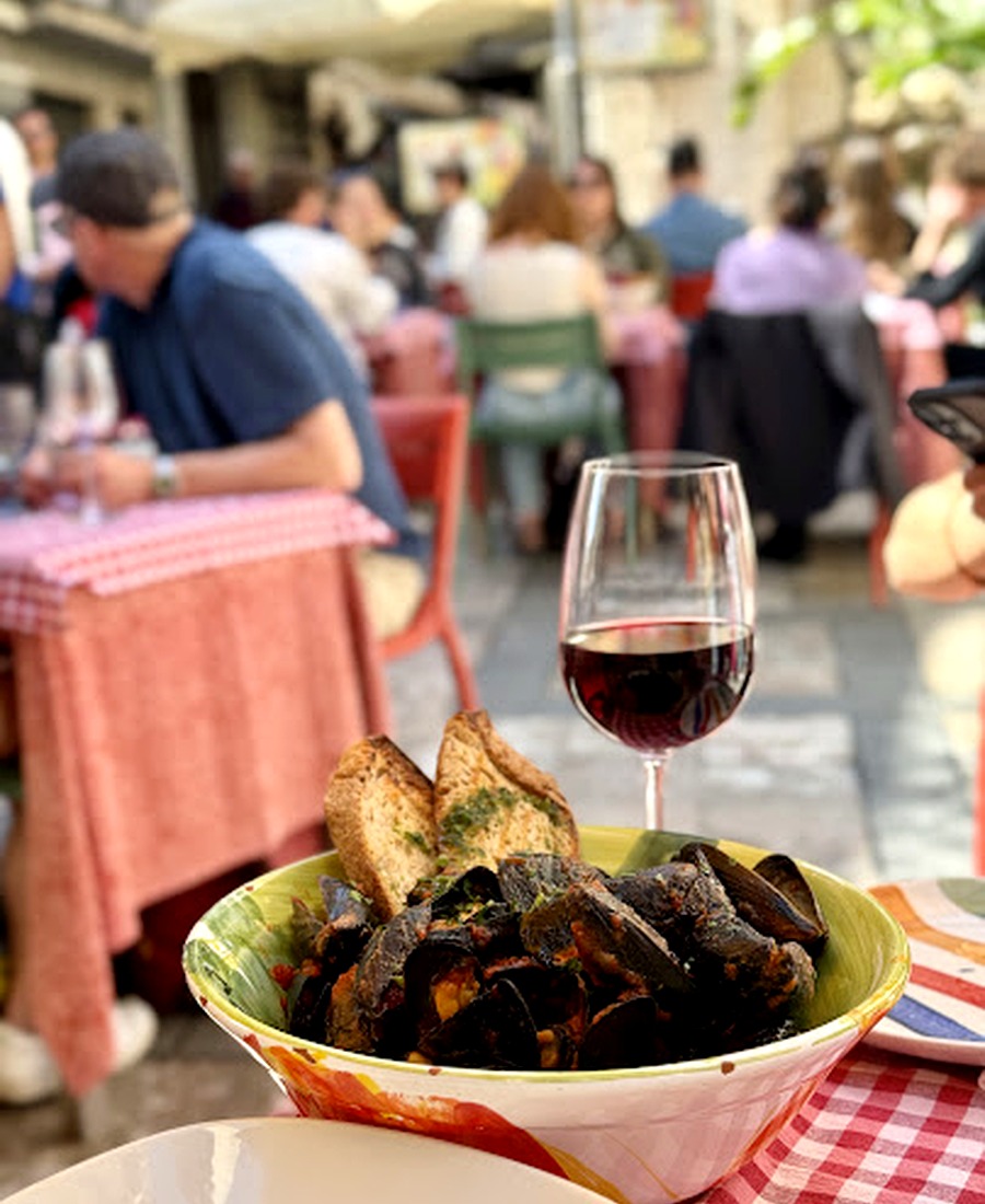 Cozze, vino rosso e tavolo a quadretti